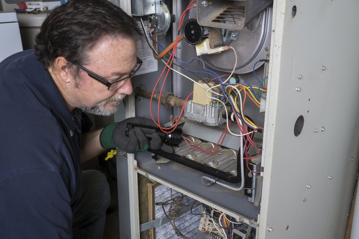 a furnace being repaired by an hvac tech