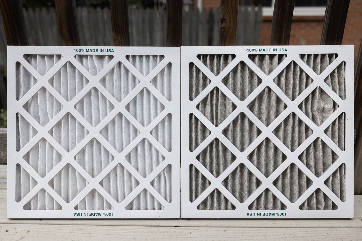 Two disposable HVAC air filters side by side, showing a clean white pleated filter compared with a dirty gray used filter.
